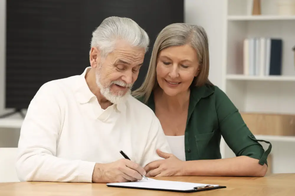 Mature couple overlooking paperwork with man signing